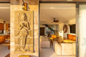 a sculpture of a woman on a wall in a living room at Villa Gaia in Ko Phangan