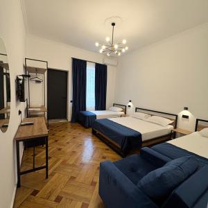 a hotel room with two beds and a couch at Polifonia Inn Borjomi in Borjomi