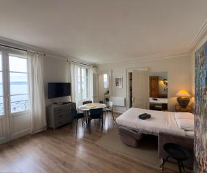 a bedroom with a large bed and a table with chairs at Le Beaupré face au lac Leman in Évian-les-Bains
