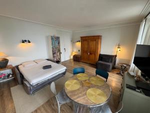 a bedroom with a bed and a table and chairs at Le Beaupré face au lac Leman in Évian-les-Bains