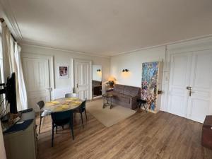 a living room with a table and a couch at Le Beaupré face au lac Leman in Évian-les-Bains