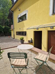 a table and chairs in front of a yellow building at Jeanmyr in Sainte-Marie-aux-Mines