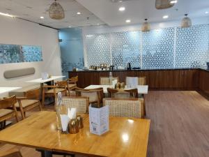 a dining room with wooden tables and chairs at FlxHo Corporate Stays - Udyog Vihar in Gurgaon