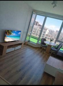 a living room with a table and chairs and windows at Shaterovi Gerbera Panoram in Plovdiv