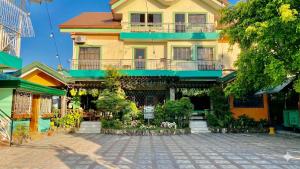 a large yellow building with balconies on a street at RedDoorz @ Greenview Hotel and Restobar Masbate in Masbate