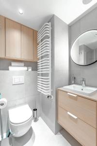 a bathroom with a white toilet and a sink at Noli Gdansk Old Town in Gdańsk