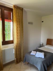 a bedroom with a bed and a window at Agri Alloggio Poggiolina in Bagnara di Romagna