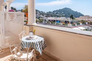 a table and chairs on a balcony with a view at Palazzo Nobili in Capri