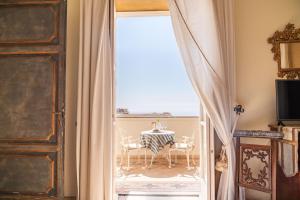 a room with a table and chairs through a door at Palazzo Nobili in Capri