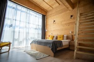 a bedroom with a bed and a large window at Beeography guest house in Vardablur