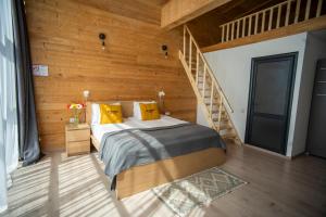 a bedroom with a bed and a wooden wall at Beeography guest house in Vardablur
