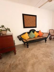 a couch with colorful pillows on it in a room at Solitude in Sri Jayewardenepura Kotte