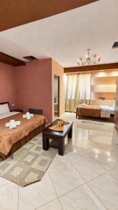 a hotel room with two beds and a table at Hotel Alysa Korce in Korçë
