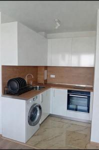 a kitchen with a sink and a washing machine at Shaterovi Gerbera Panoram in Plovdiv