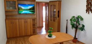 a living room with a table and a tv at Komfortowy Apartament na wyłączność 2 Sypialnie Blisko Centrum in Gorlice