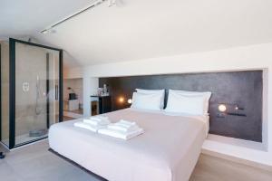 a bedroom with a large white bed with towels on it at Le Relais du Lierre - Conero Nature Retreat in Poggio