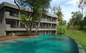 a resort with a large swimming pool in front of a building at HOUSE Sira Lombok in Tanjung