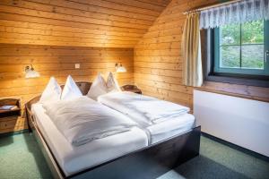 a bedroom with a bed in a wooden room at Hapimag Ferienwohnungen Sonnleitn in Sonnenalpe Nassfeld +119 photos