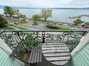 a bench on a balcony with a view of the water at Le Chaplin face au lac Léman in Évian-les-Bains