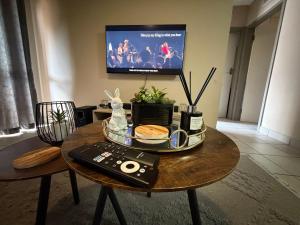 a living room with a coffee table with a tv at Sharing living area Apartment in Centurion +5 photos