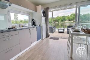 a kitchen with a view of the water and a table at TI WAR AN DOUR in Guégon +17 photos
