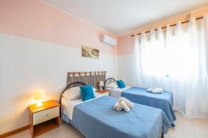 a bedroom with two beds and a window at Il Gabbiano rooms in Donnalucata