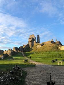 a castle sitting on top of a grassy hill at Ballard Down View, Swanage 2 Bed in Swanage