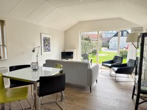 a living room with a couch and a table and chairs at Op 't Landtweg 35a in Callantsoog