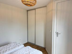 a bedroom with a bed and a chandelier at Op 't Landtweg 35a in Callantsoog