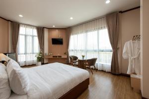 a hotel room with a large bed and a desk at Peya Rama-7 Hotel in Bang O