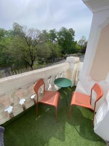 a patio with two chairs and a table on a balcony at Extravagant Apartments km0 PrimariaArad in Arad