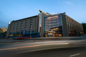 a large building with a sign on the front of it at NH Prague City in Prague