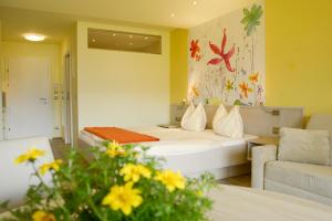 a hotel room with a bed and a couch at Seepark Drobollach in Drobollach am Faaker See
