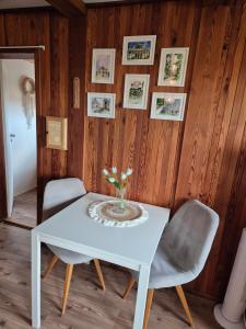 a white table with two chairs and a vase of flowers at Malovaný sklípek in Hlohovec +20 photos