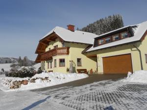 dom z garażem w śniegu w obiekcie Schitter w mieście Sankt Andrä im Lungau