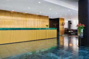 a lobby of a hotel with a yellow wall at NH Prague City in Prague +67 photos