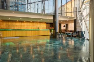 a lobby with a table and chairs in a building at NH Prague City in Prague