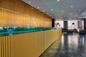 a bar in a hotel lobby with a fish tank at NH Prague City in Prague