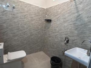 a bathroom with a white toilet and a sink at Nadaa Organic Farms in Khammam