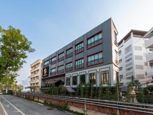 a building on a street with buildings at Peya Rama-7 Hotel in Bang O