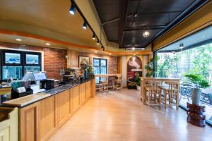 a restaurant with a bar with tables and chairs at Peya Rama-7 Hotel in Bang O