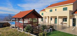 a house with a gazebo next to a pool at Villa Ruzin Dvor in Donji Vinjani