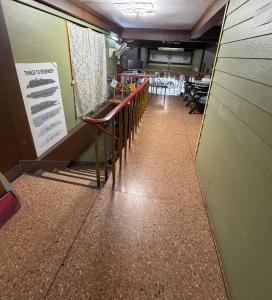 a long hallway with tables and chairs in a restaurant at Yuma Tashi Hostel in Bangkok