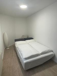 a white room with a bed with white sheets at Ferienwohnung Moor in Wickede (Ruhr)