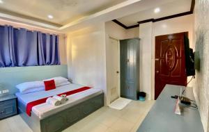 a bedroom with a bed and a television in it at RedDoorz @ Greenview Hotel and Restobar Masbate in Masbate