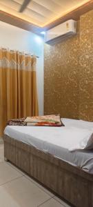 a bed in a room with a curtain at Om Dayama Please in Khātu