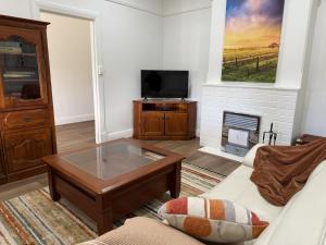 a living room with a coffee table and a tv at Perrys Place in Nuriootpa