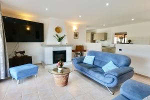 a living room with a blue couch and a tv at Villa IS CARCURIS Jennas in Cardedu