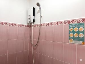 a shower in a bathroom with pink tiles at RedDoorz @ Greenview Hotel and Restobar Masbate in Masbate