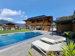 a villa with a swimming pool and a house at Pension Edelweiß in Sankt Johann im Pongau